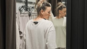 Woman closes curtain in fitting room to ensure privacy while trying on clothes Scene highlights importance of personal space and comfort while shopping for clothes Concept of choosing clothes - Powered by Shutterstock - Get 15% off with code: PIKWIZARD15