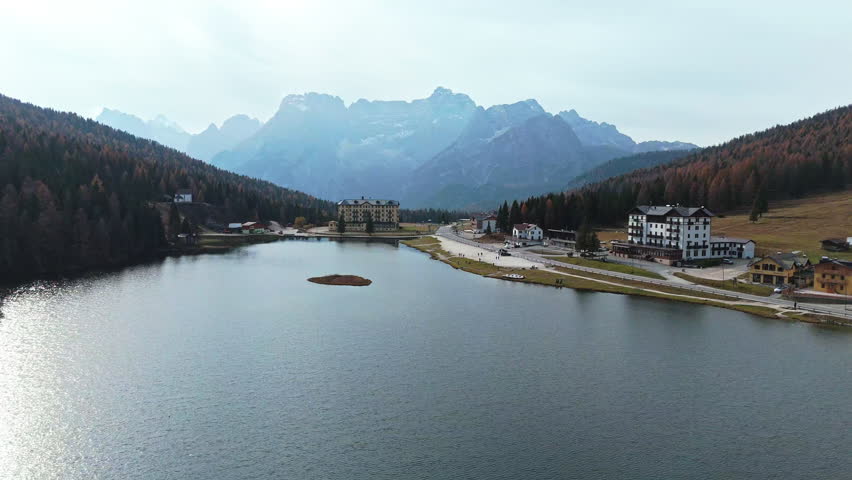 Scenic view of Misurina Lake with surrounding mountains and lakeside hotels on a calm day