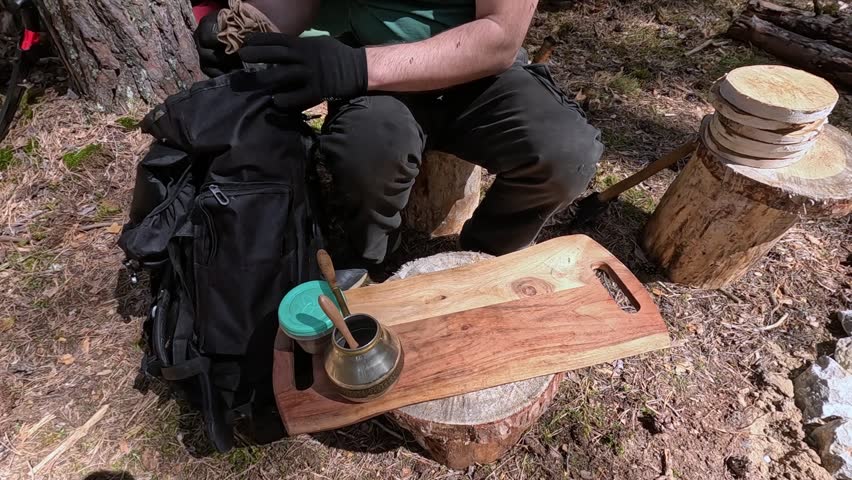A tourist takes dishes out of his backpack in nature
