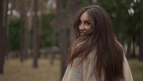 A smiling woman with vibrant, keratin-enriched hair glances back in a serene forest. Her silky, strong strands reflect optimal hair care, nourished with essential vitamins and proteins, showcasing the - Powered by Shutterstock - Get 15% off with code: PIKWIZARD15