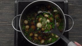A ladle scoops marinated champignons from a pot with spices and marinade. Top view. High quality 4k footage - Powered by Shutterstock - Get 15% off with code: PIKWIZARD15