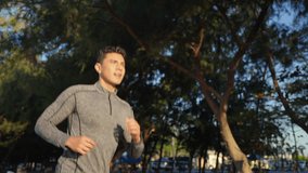 Wellness healthcare motivation. Asian man in sportswear and smartwatch jogging exercise on beach road. Healthy guy enjoy outdoor active lifestyle sport training fitness workout running at seaside. - Powered by Shutterstock - Get 15% off with code: PIKWIZARD15