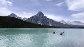 Kayakers enjoying the turquoise waters of Bow Lake in Banff National Park with the Canadian Rockies in the background, Canada - Powered by Shutterstock - Get 15% off with code: PIKWIZARD15