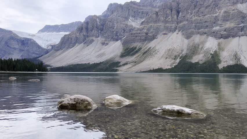 Tranquil scene of Bow Lake reflecting Crowfoot Glacier and surrounding mountains in Banff National Park, showcasing Canadian Rockies natural beauty, Canada