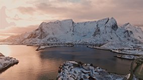 Flying over Sakrisoy towards Reine in Lofoten at dramatic sunset sky and on a calm day with light waves - Powered by Shutterstock - Get 15% off with code: PIKWIZARD15