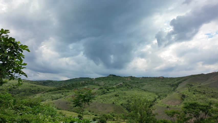 Dark clouds moving across the sky over the hills from the wind