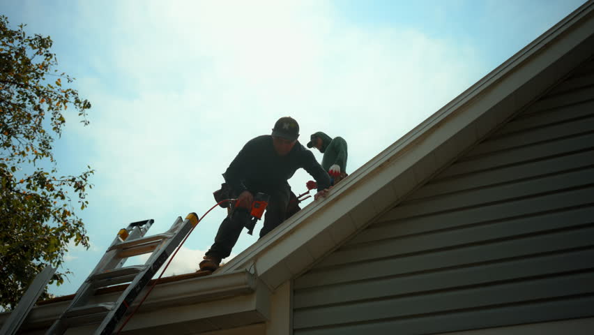 Roofers installing a new roof on an house. Element installing new roof