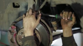 Mechanic working with car clutch, dismantling process. Close-up.