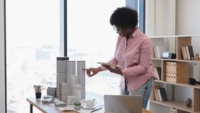 African American woman architect mid-30s develops modern city project using digital tablet office environment. - Powered by Shutterstock - Get 15% off with code: PIKWIZARD15