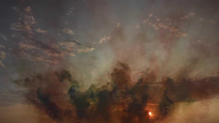 Dramatic sunset sky with smoke clouds during fireworks display in dusk cloudscape