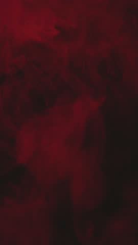 Red vapor or smoke on a black background in vertical.