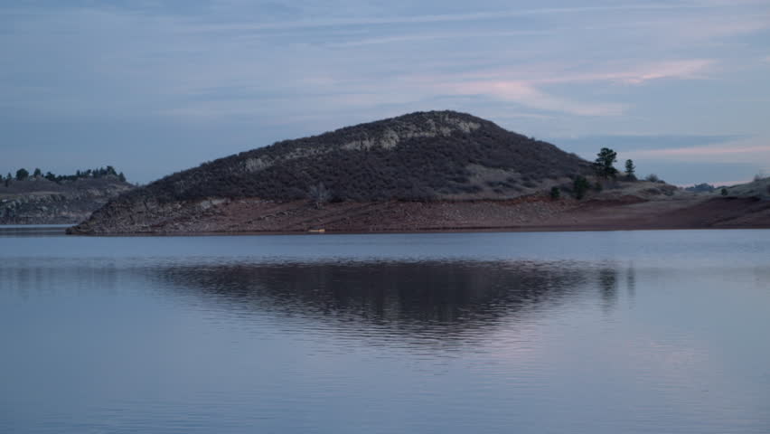 mountain lake with sandstone cliffs at dusk - Horsetooth Reservoir in northern Colorado with a distant kayak