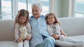Happy family at home. Two little girls sisters twins grandmother enjoying time together. Good time at home. Grandma granddaughters child kids playing toys hugging together. Family generations - Powered by Shutterstock - Get 15% off with code: PIKWIZARD15