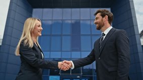 Closeup business people handshake in front modern office building. Confident businessman businesswoman shaking hands during business interaction outdoors. Professional partners initiating agreement - Powered by Shutterstock - Get 15% off with code: PIKWIZARD15