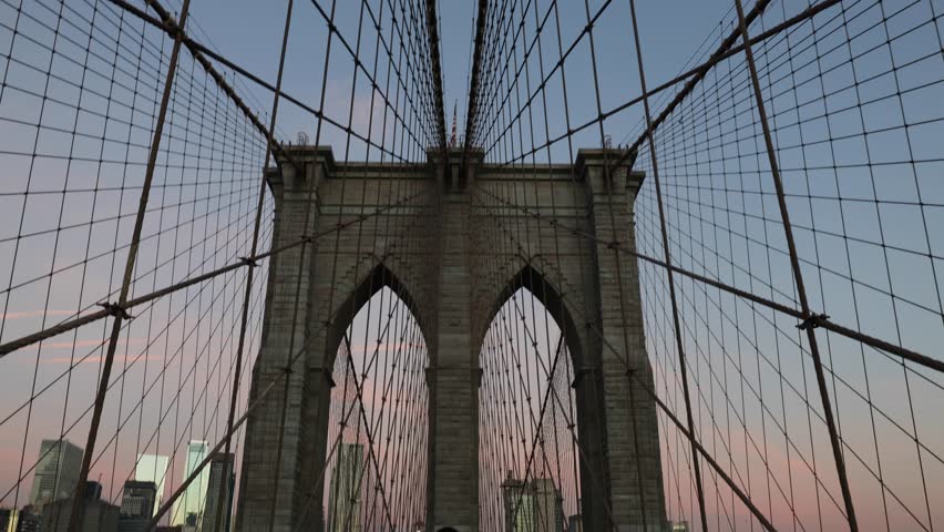 panning up at the brooklyn bridge at sunrise (beautiful suspension overpass pedestrian walkway between manhattan and borough new york city) nyc landmark travel tourism destination