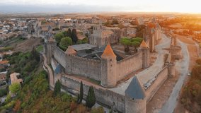 Aerial view of the medieval city of Carcassonne town and its fortress castle at sunrise, southern France.Famous historic fortress with its iconic medieval towers in the beautiful morning light - Powered by Shutterstock - Get 15% off with code: PIKWIZARD15