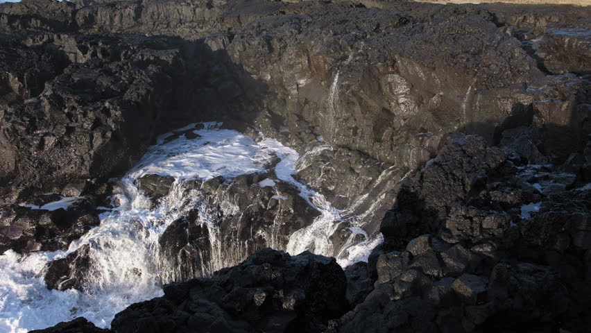Huge waves crash on the shore, Rocky ocean coast in Iceland, Basalt cliff, Awesome power of waves breaking over dangerous rocks