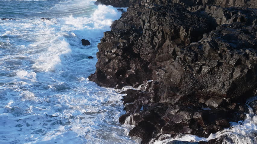 Huge waves crash on the shore, Rocky ocean coast in Iceland, Basalt cliff, Awesome power of waves breaking over dangerous rocks