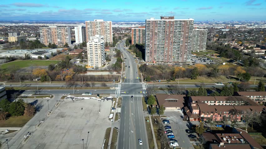 Low level aerial view of a corridor of high density high-rise residential buildings located near the Bramalea City Centre in Brampton Ontario. This clip is recorded on a mild February day.