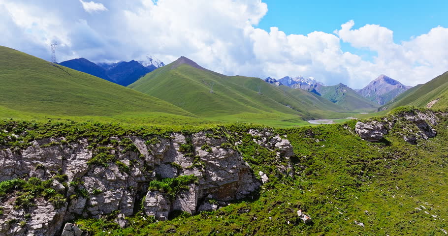 Aerial view of curved river and green grassland with mountain natural landscape in Xinjiang. Duku Highway is the most beautiful highway in China.