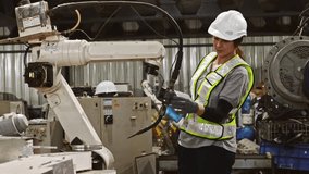 Female robot engineer holding laptop walks inspect robot hydraulic welding equipment during maintenance and safety check before controlling the system and programming the robot to work. - Powered by Shutterstock - Get 15% off with code: PIKWIZARD15