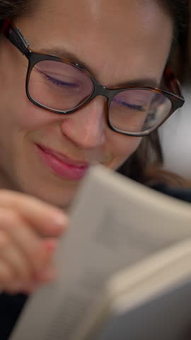A woman is truly enjoying a captivating book while immersed in a cozy and inviting setting