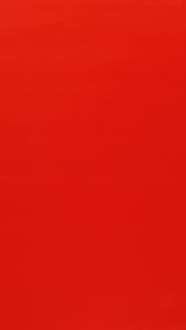 Hand giving present gift box with red ribbon bow on red background. Person showing gift box for for Valentine's Day, Christmas or Birthday. Holiday present. Vertical video