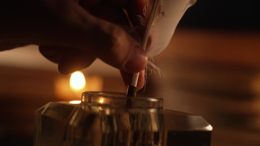 Man puts down feather Quill Pen in glass Inkwell. Vintage cozy scene from 18th or 19th century. Warm Glow Light Of Old Candle. Books