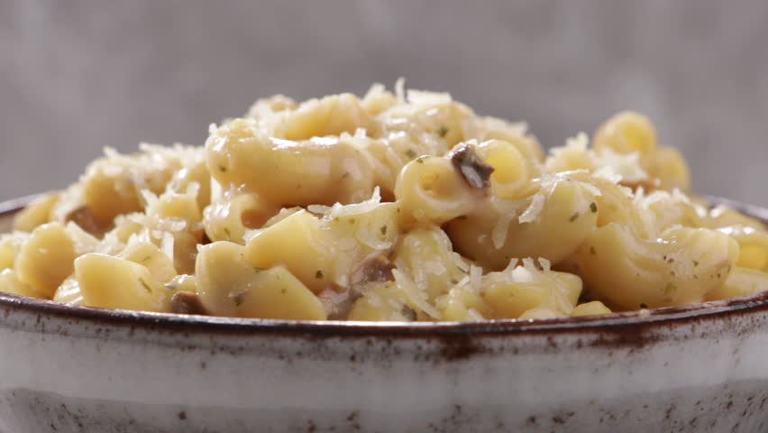 mac and cheese in bowl close up on light surface rotation food .mov
