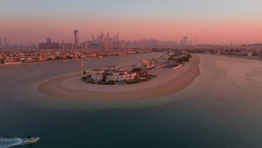 The breathtaking aerial view of Palm Jumeirah in the UAE, captured beautifully at sunset, showcases its iconic palm treelike shape and the stunning skyline that surrounds it