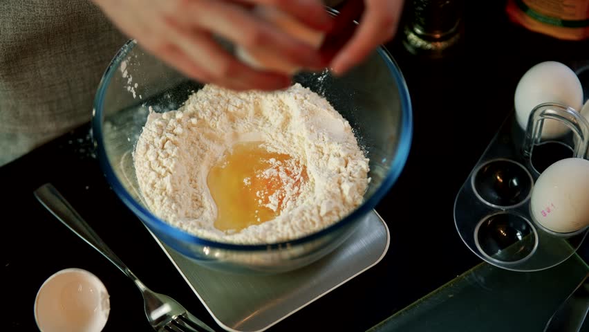 Preparing pancake dough. pours whipped eggs into flour. Pastry chef prepares dough at bakery using traditional recipe. homemade cookies at home. Morning breakfast food preparation. cooking dough