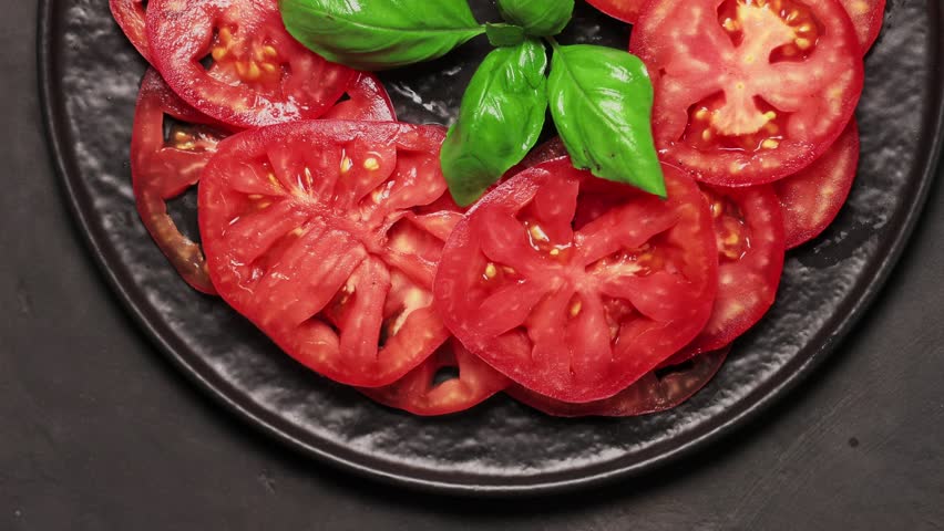 Sliced Tomatoes with Fresh Basil on Dark Plate for Healthy Mediterranean Recipe, Top View