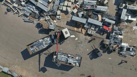 Aerial view of a scrapyard with two large trucks loading and transporting metal scraps. Concept of recycling, waste management, and environmental sustainability - Powered by Shutterstock - Get 15% off with code: PIKWIZARD15