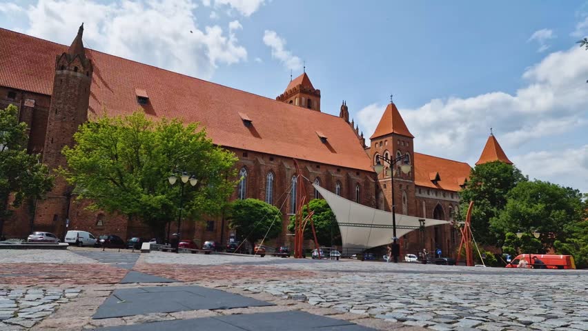 time lapse. Historic brick Cathedral with orange roofs and vibrant square in Kwidzyn, Poland