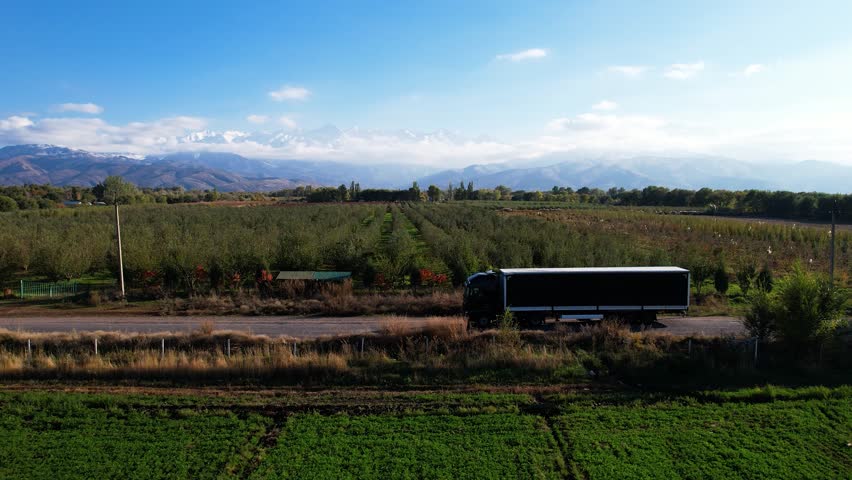 "Scenic Orchard with Truck and Mountain Backdrop"

