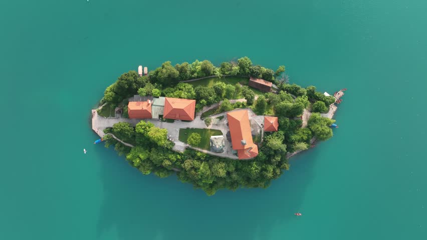 A Drone shot over Lake Bled with a small island and green vegetation around