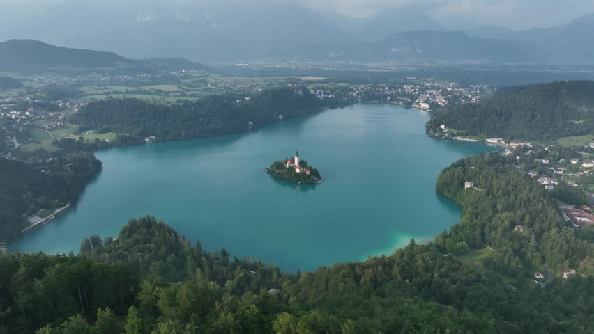 A Drone shot over Lake Bled with a small island and green vegetation around