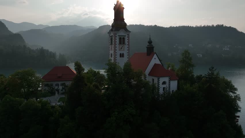A Drone shot over Lake Bled with a small island and green vegetation around