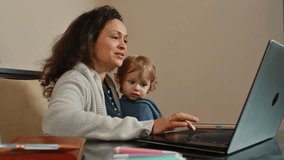 Mother Working from Home While Caring for Her Young Child - Powered by Shutterstock - Get 15% off with code: PIKWIZARD15