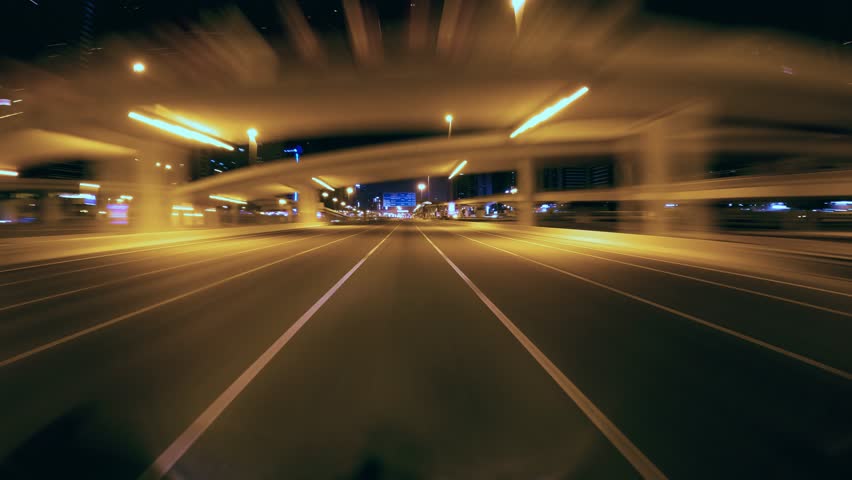 Drive lapse on highway in Dubai marina with moving vehicles and city lights