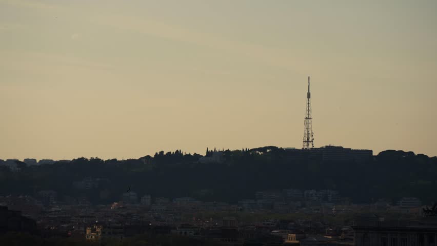 Telecommunications tower standing tall against a sunset sky in Rome, Italy