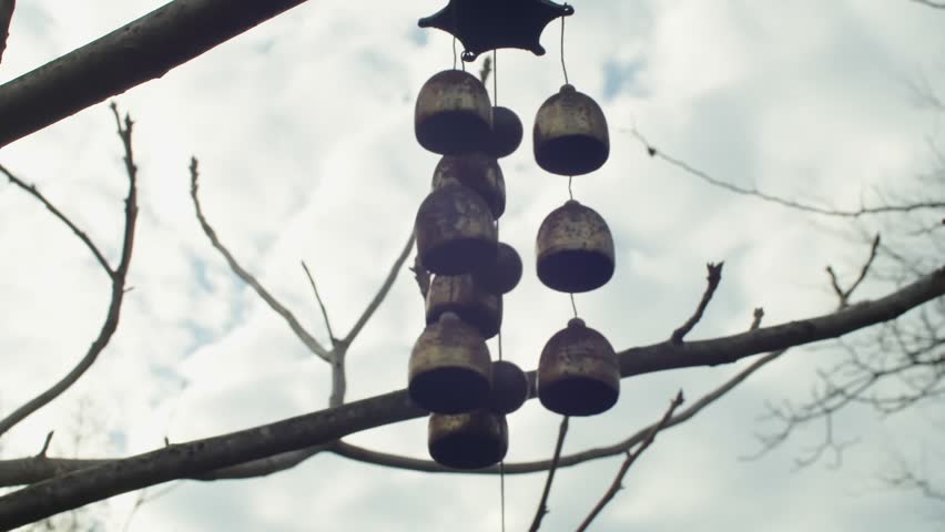 Elegant and Harmonious Wind Chimes Gracefully Hanging from a Tree Branch in Natures Embrace