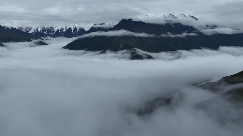 Aerial footage landscape of foggy snow capped mountains in sichuan, China, time lapse