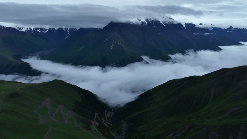 Aerial footage landscape of foggy snow capped mountains in sichuan, China