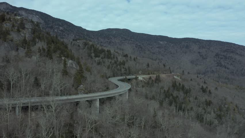 Aerial dolly along winding suspended road of Linn Cove Viaduct along Blue Ridge Parkway, North Carolina