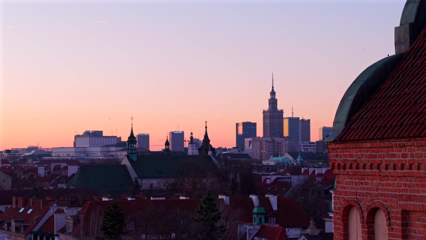 Drone reveals St. Casimir roman catholic church with Downtown Warsaw skyline buildings in background at dawn, Establishing shot
