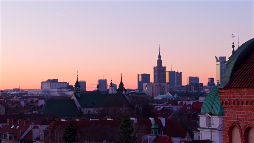 Drone reveals St. Casimir roman catholic church with Downtown Warsaw skyline buildings in background at dawn, Establishing shot