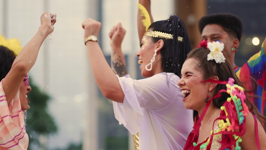 Smiling Friends Throwing Confetti at a Brazilian Carnival Celebration. Joyful Group Dressed in Colorful Costumes Enjoying Vibrant Carnaval Festivities Outdoors