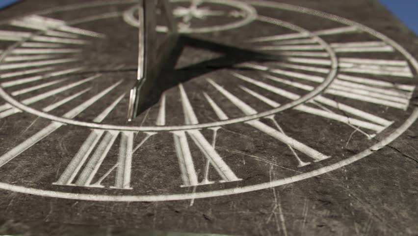 A macro panning closeup of a sundial in a 12 hour time-lapse going from morning until night