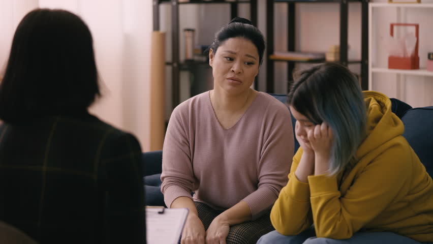 Mother and her young daughter attend a therapy session to address teen issues